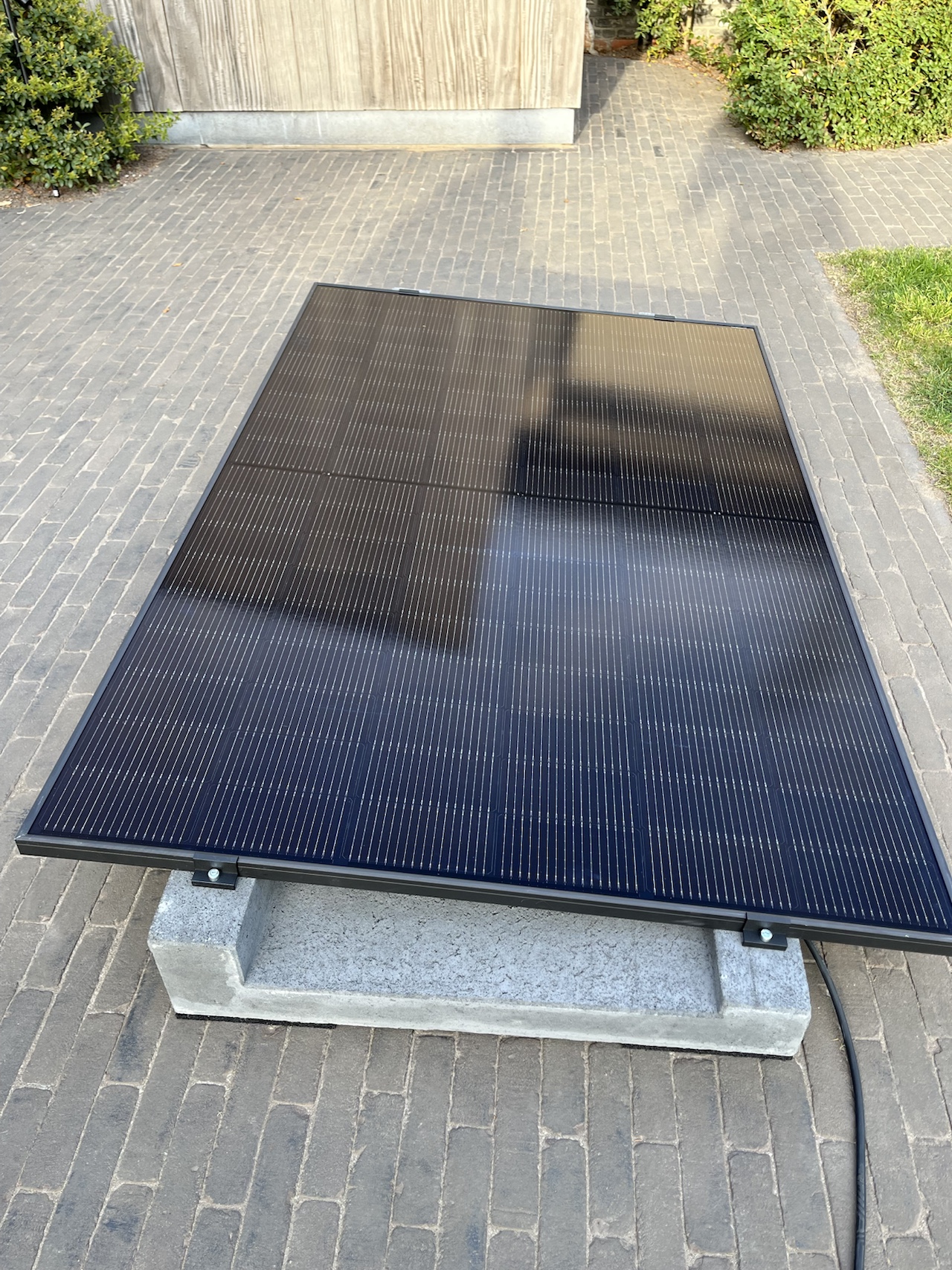 Optisun plug & play zonnepaneel, geplaatst op betonblokken